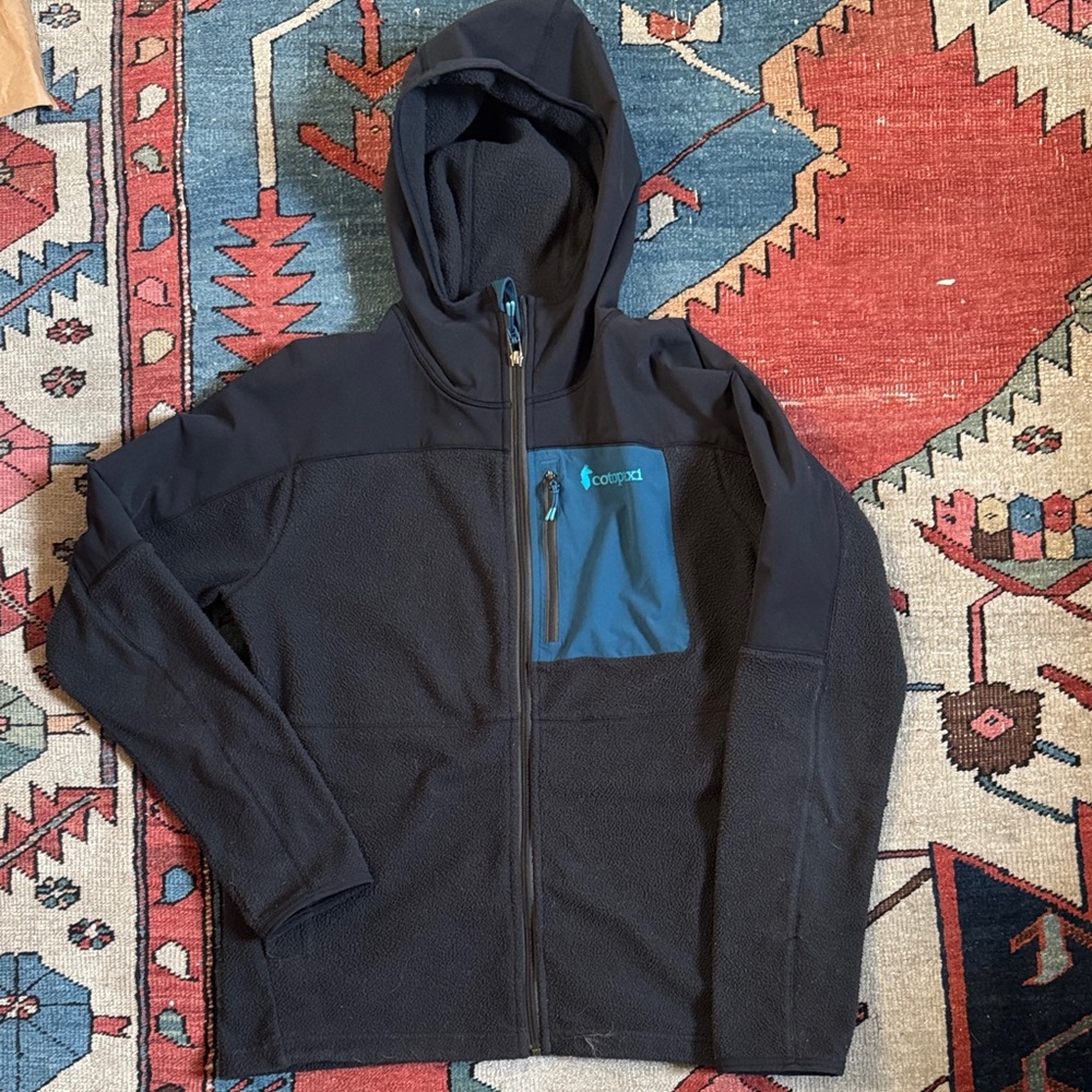 Cotopaxi Women’s Abrazo Fleece, Hooded. Dark Navy/Black with blue pocket, size L